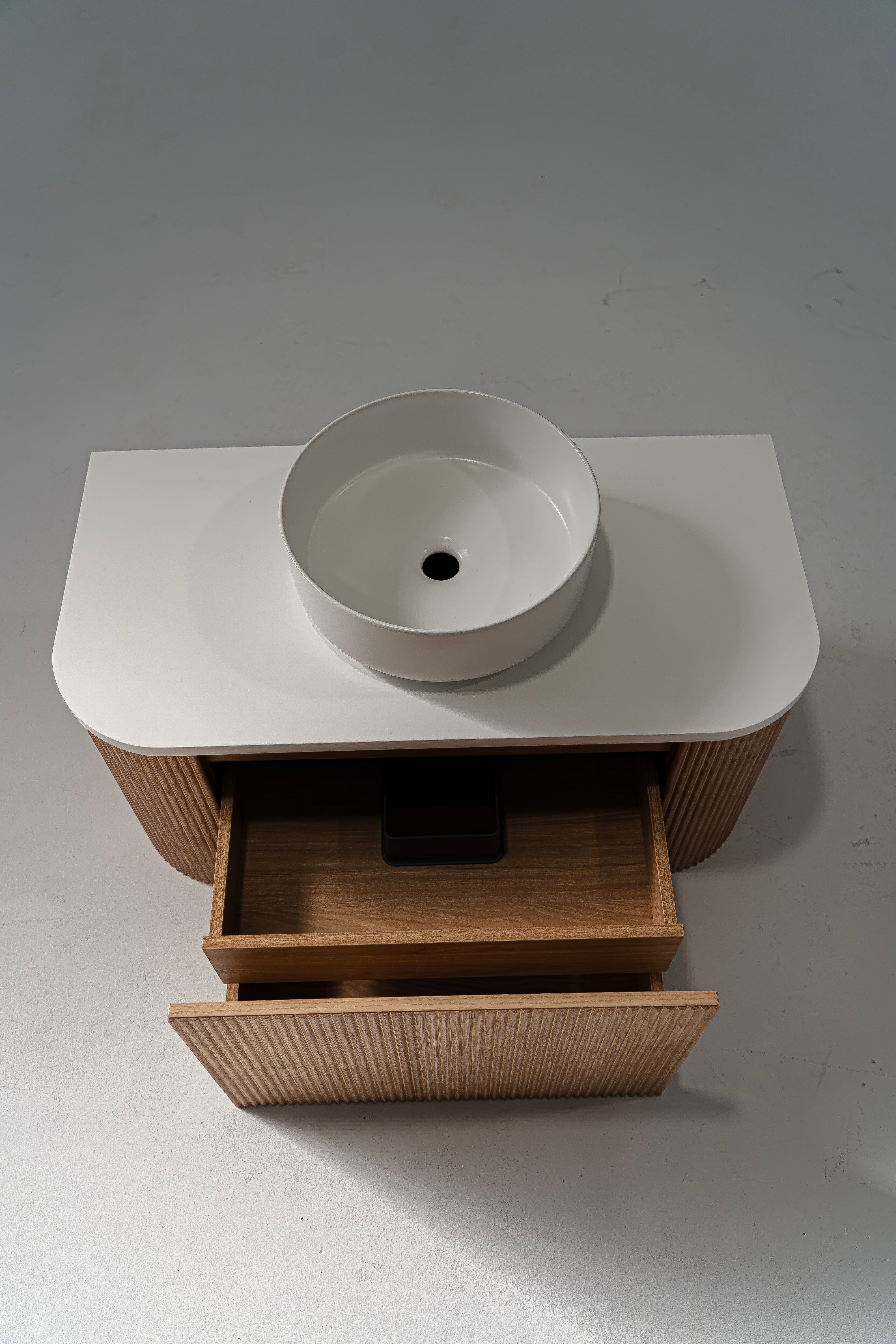 A Portofino Oak Flute Vanity Unit with a white solid surface benchtop and a matte white ceramic basin, featuring a wood grain finish and a modern design.